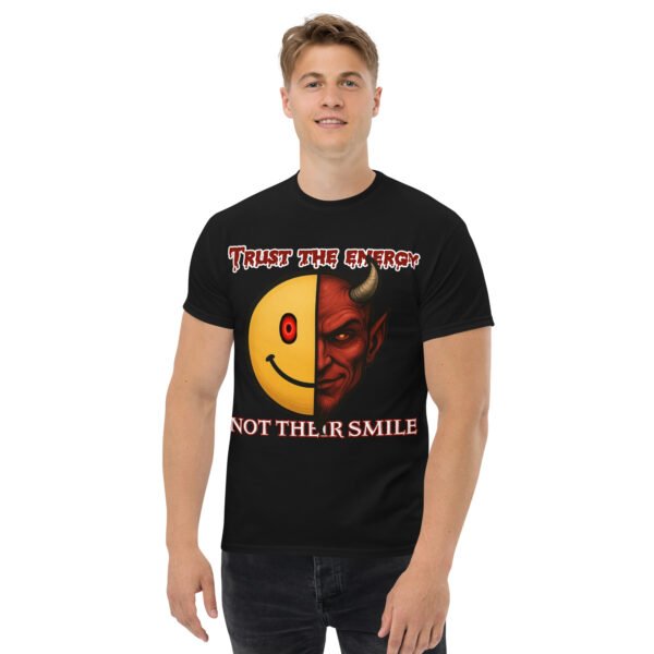 Black Men's t-shirt with bold graphic of a half-smiley face and half-demon face, text reads “Trust the Energy, Not Their Smile.”